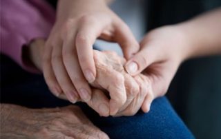 enfermera cogiendo la mano de mayor