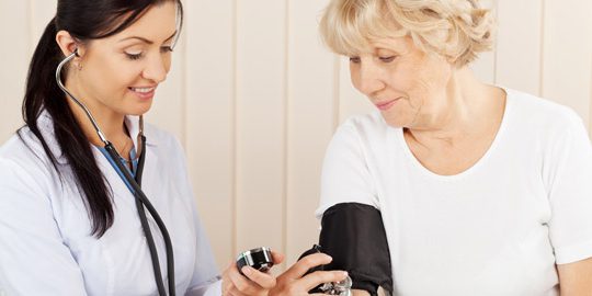 enfermera comprueba la presión sanguinea