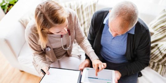 enfermera enseña tables a persona mayor