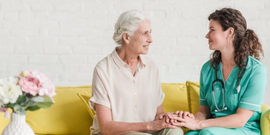 Enfermera habla con paciente mayor